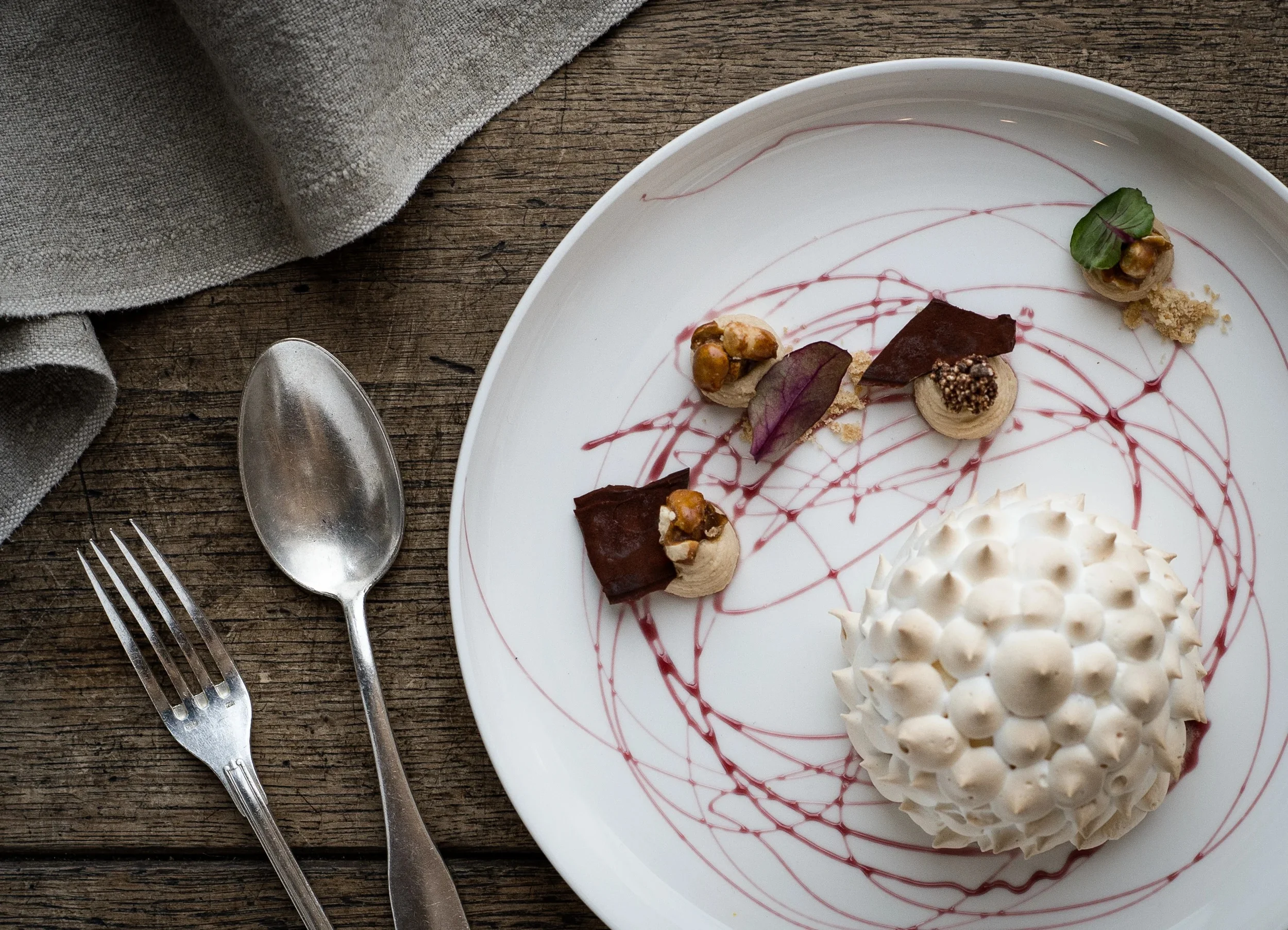Artistic dessert presentation featuring a spiked meringue dome.